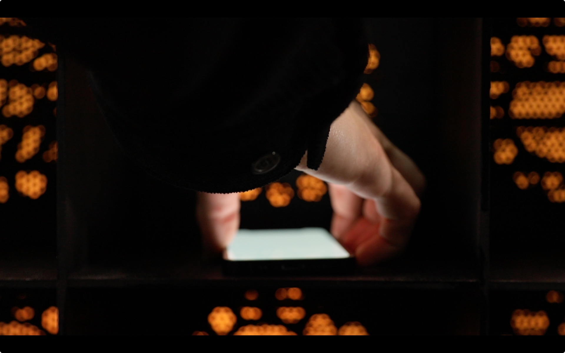 MEMENTO — close-up of a hand plugging a phone into the deposit box
